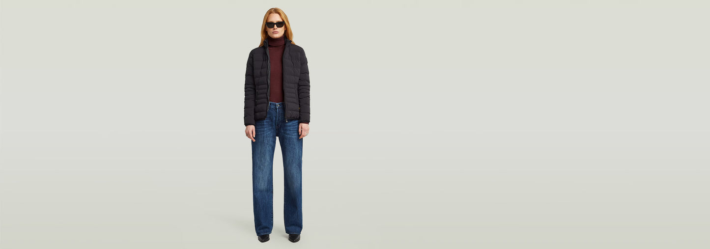 Mujer usando la Cazadora Foundation Padded Short con jeans anchos y gafas de sol, estilo moderno y ajustado.
