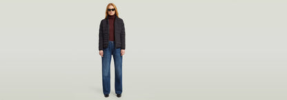 Mujer usando la Cazadora Foundation Padded Short con jeans anchos y gafas de sol, estilo moderno y ajustado.