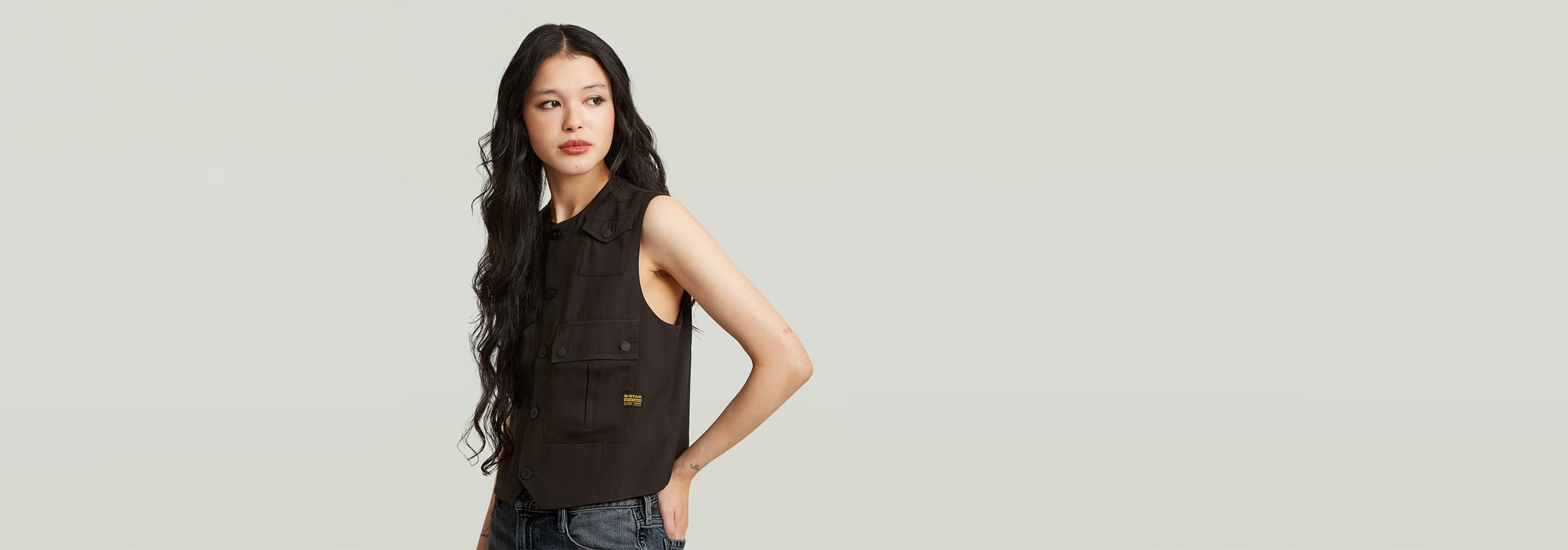 Chaleco Pocket en color negro con bolsillos, ajuste a medida y diseño elegante, modelo femenino.