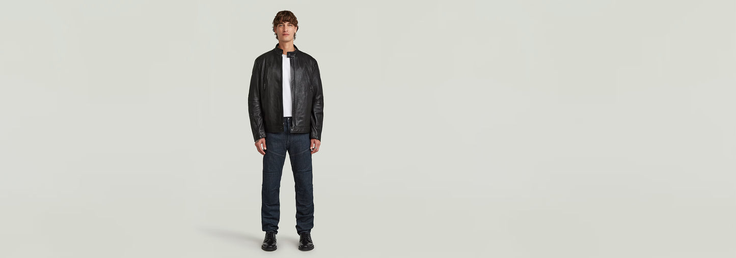 Hombre modelando la Chaqueta Biker Leather con cuello alzado y cierre de cremallera, en fondo neutro.