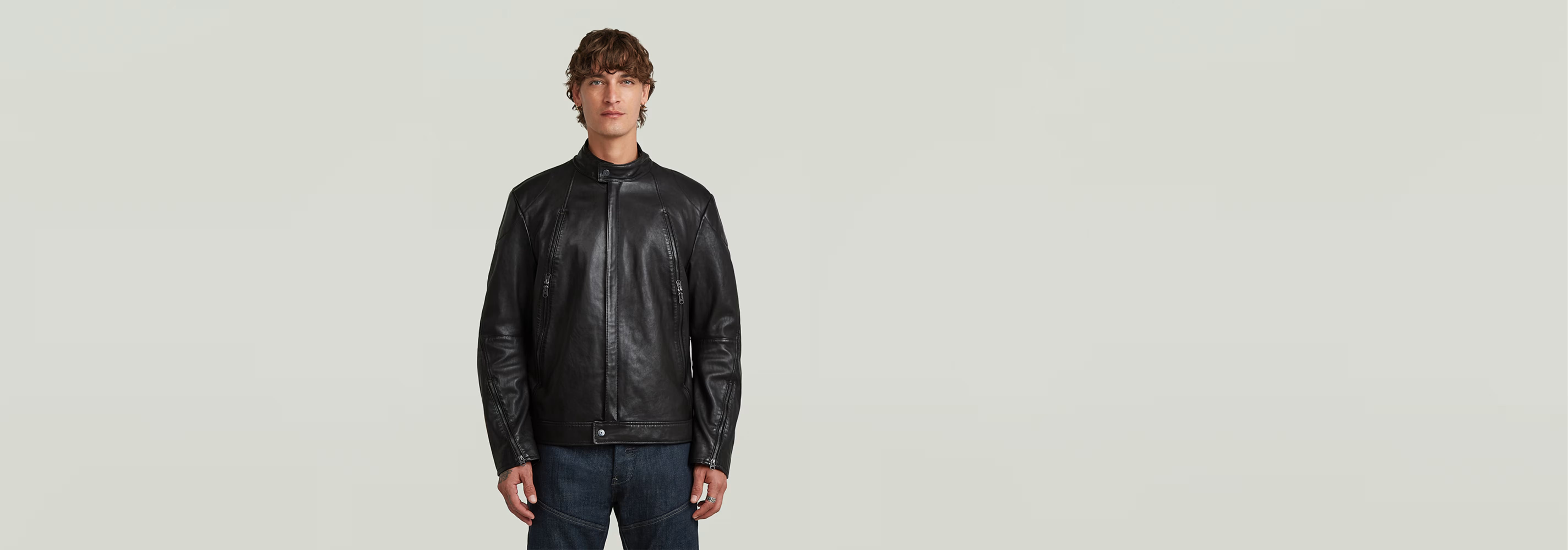 Hombre usando una chaqueta Biker Leather de cuero negro con cuello alzado y cierre de cremallera.