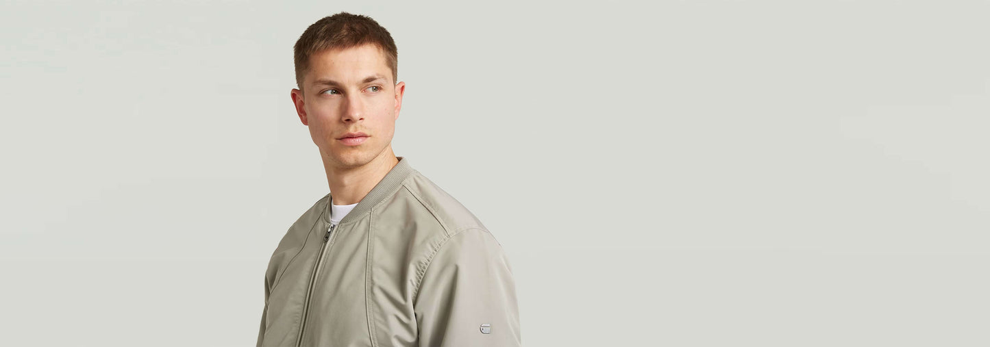 Modelo luciendo una chaqueta Bomber Unpadded en color gris, con diseño recto y bolsillos.
