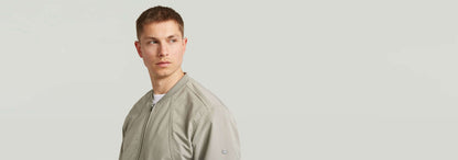 Modelo luciendo una chaqueta Bomber Unpadded en color gris, con diseño recto y bolsillos.