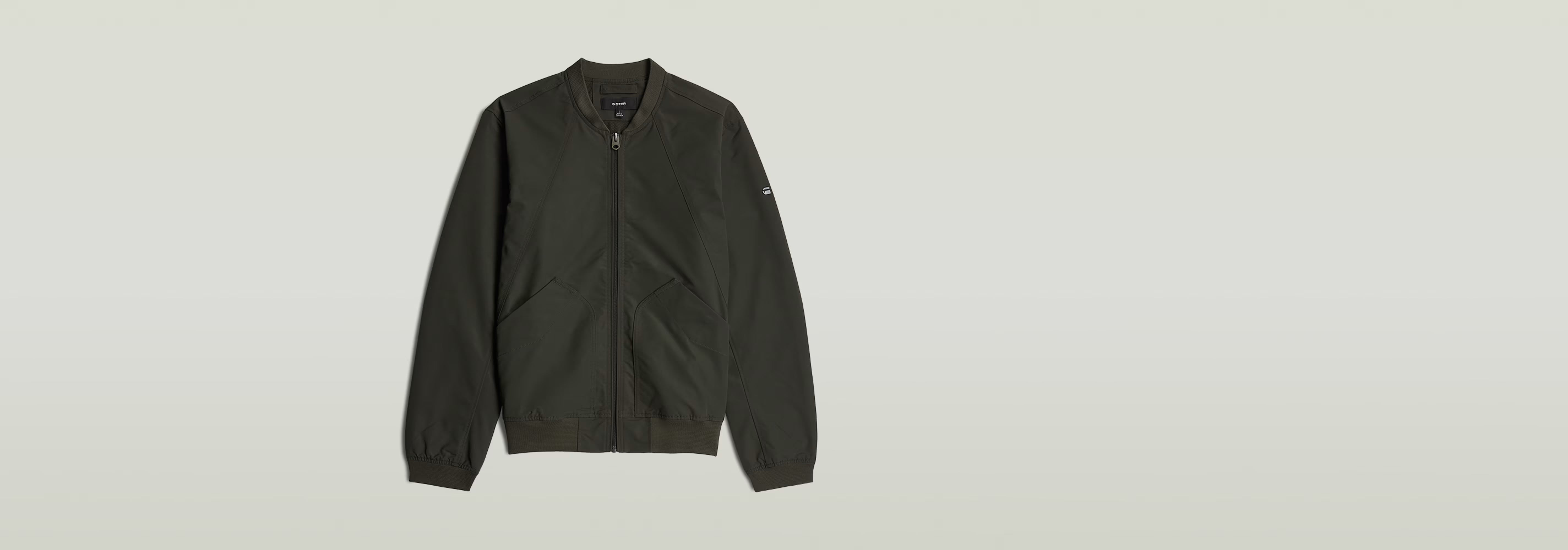 Chaqueta Bomber Unpadded en color verde oscuro con cierre de cremallera y corte recto.