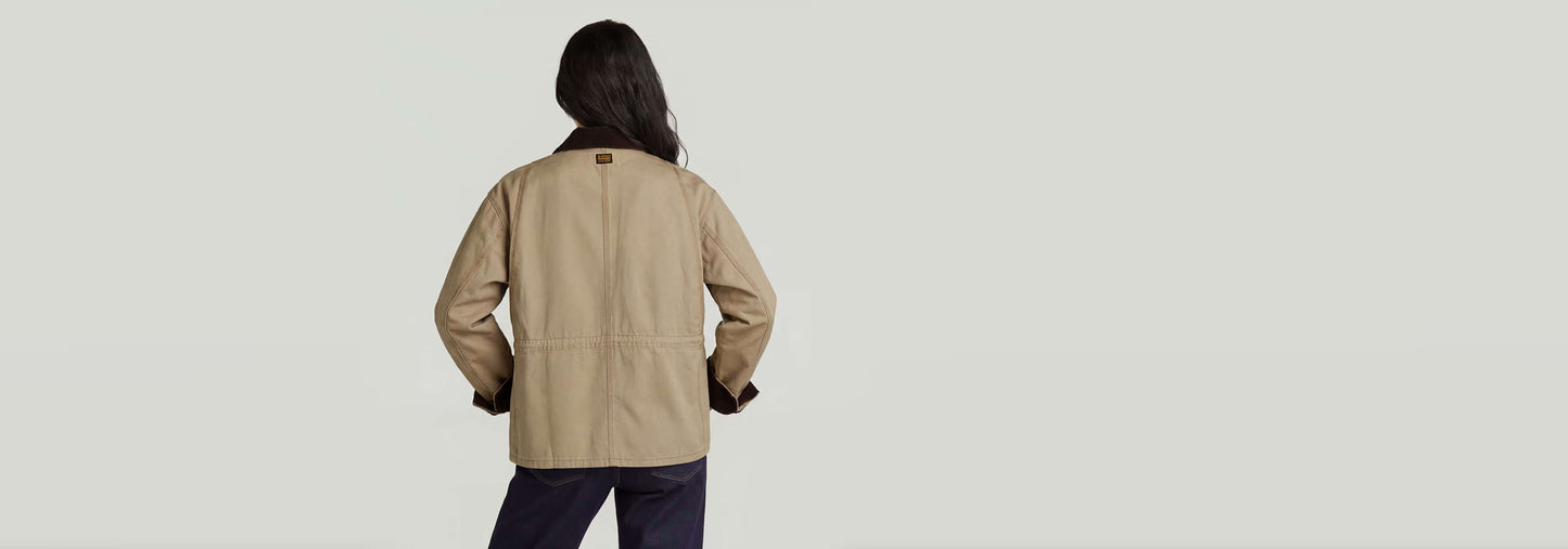 Mujer luciendo la chaqueta Boyfriend Barn desde atrás, mostrando su corte holgado y diseño de bolsillo.