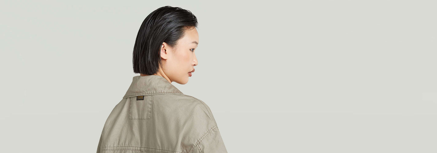 Mujer con chaqueta Field de corte extragrande y cuello alzado, vista desde atrás.