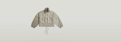 Chaqueta Field de corte extragrande con cuello alzado y dos bolsillos grandes en color beige.