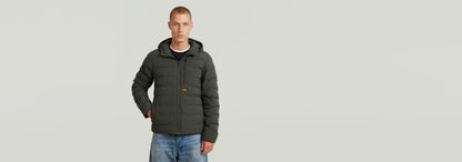 Chaqueta Foundation Hooded Liner, acolchada y forrada, modelo masculino con capucha, cómoda y ligera.