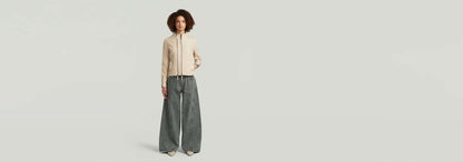 Mujer modelando la Chaqueta Lynn Leather Biker con pantalones anchos en fondo claro.
