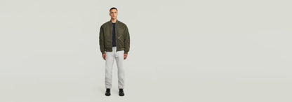 Modelo usando la chaqueta GA-1 Lightweight Padded Bomber con pantalones claros y fondo neutro.