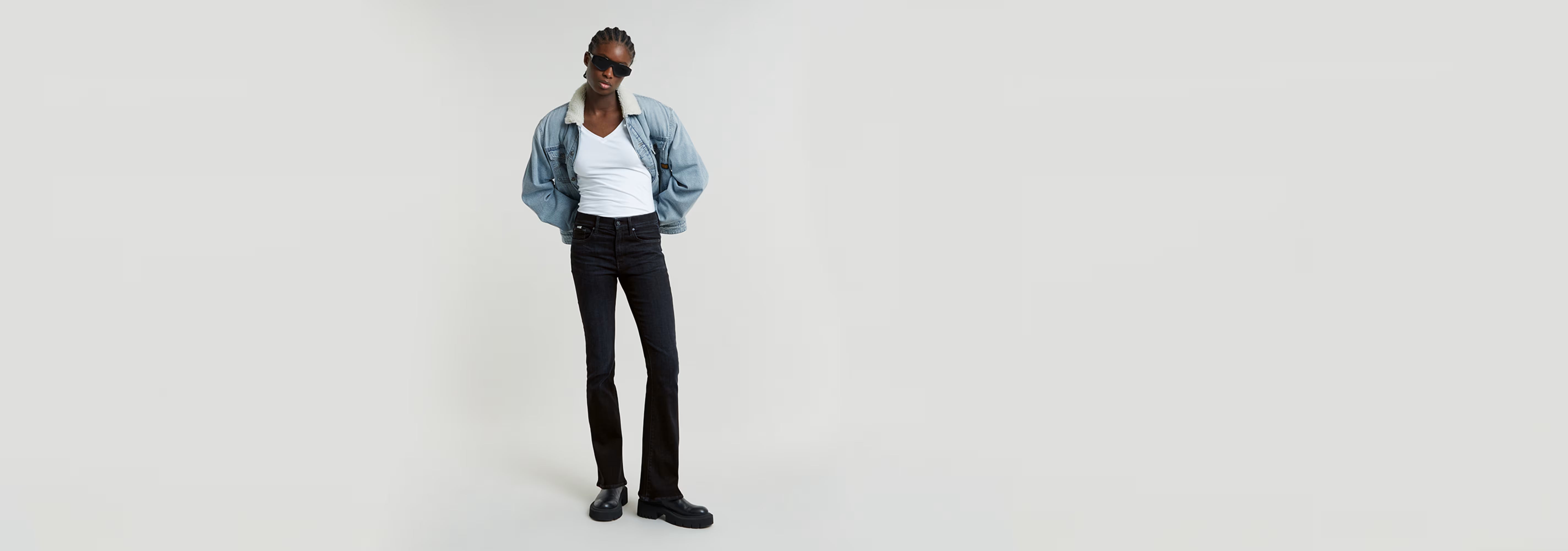 Modelo usando los Jeans 3301 Flare con chaqueta de mezclilla y camiseta blanca.
