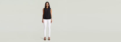 Modelo luciendo Jeans 3301 Skinny con blusa negra y tacones, fondo claro.