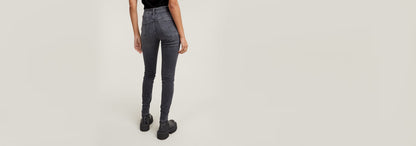 Mujer de espaldas usando Jeans 3301 Skinny en color negro desgastado con corte pitillo y talle medio.