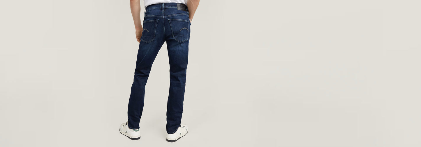 Hombre vistiendo Jeans 3301 Slim desde atrás, mostrando su diseño y ajuste.