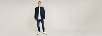Modelo usando Jeans 3301 Slim con camiseta y chaqueta, fondo neutro.