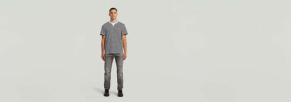 Modelo luciendo Jeans Biker Patched Slim con camiseta de rayas en fondo neutro.