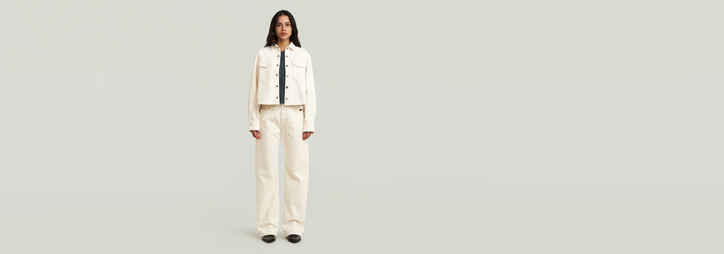 Modelo vistiendo Jeans Bowey Barrel y chaqueta blanca sobre fondo neutro.