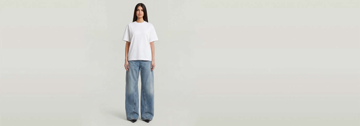Modelo usando Jeans Contor Barrel Wide, con camiseta blanca y corte holgado en la parte inferior.