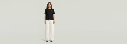 Modelo usando jeans Contor Barrel Wide con camiseta negra y pantalones anchos blancos.