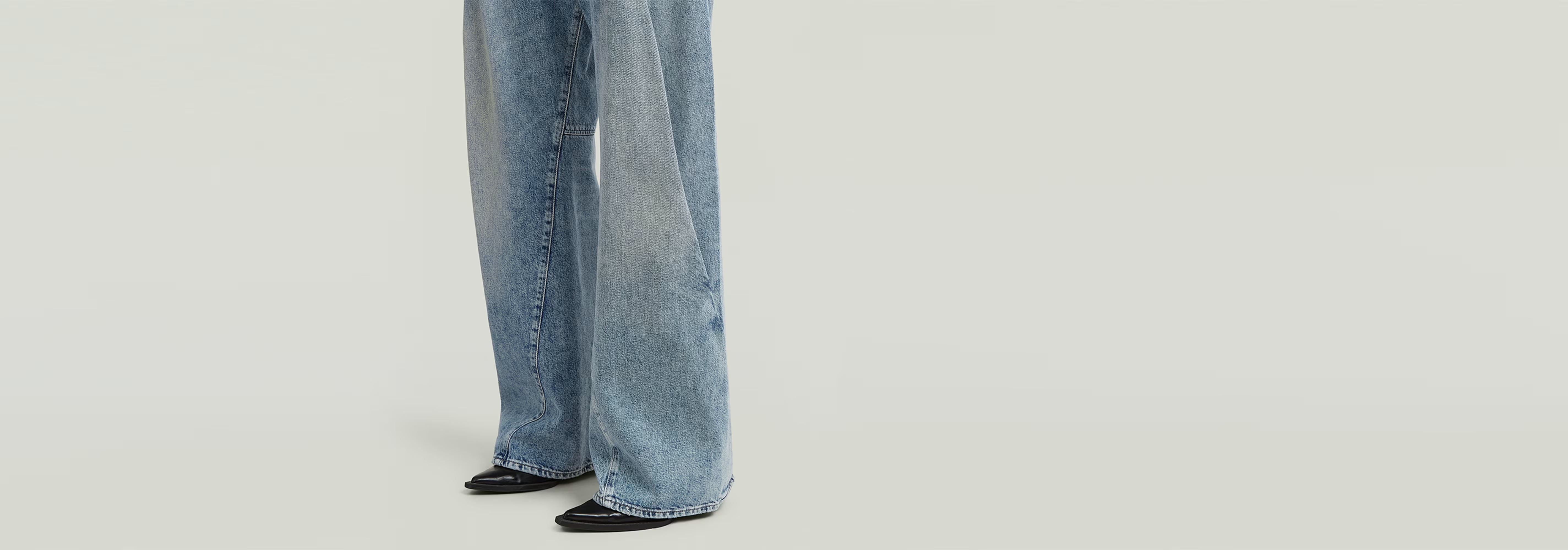 Pantalones de jeans Contor Barrel Wide Pleat con corte holgado y pernera larga sobre fondo claro.