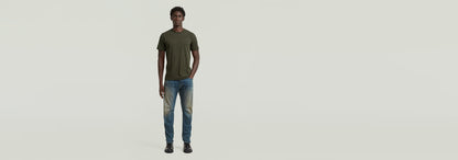Hombre usando Jeans Contor Slim, parte de la colección Anatomic Denim en un fondo neutro.