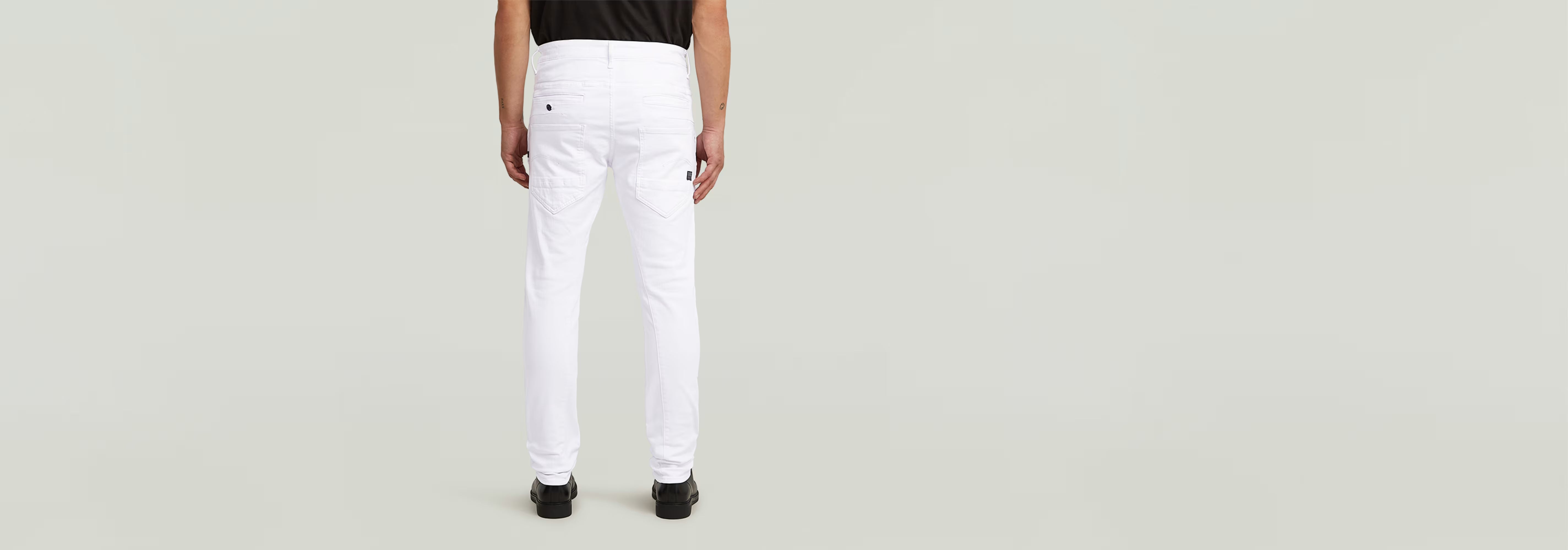 Jeans D-Staq Slim en color blanco, vista trasera de un hombre con camiseta negra.