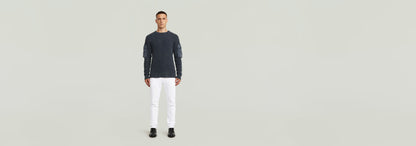 Modelo vistiendo Jeans D-Staq Slim con camiseta de manga larga en fondo neutro.