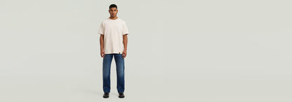 Hombre usando Jeans Dakota Regular Straight con camiseta, posando en un fondo claro.