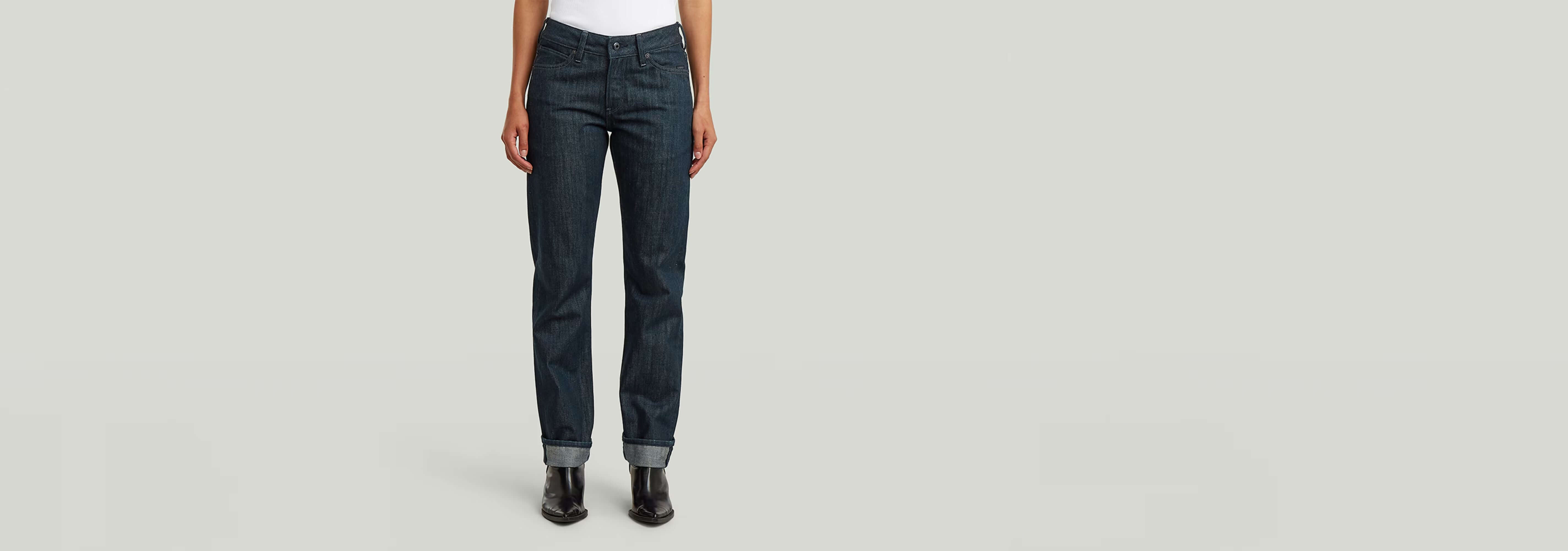 Jeans G-STAR Lennoxx Slim Straight en color índigo, corte recto y medio, modelo con camiseta blanca y botas negras.