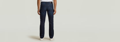 Modelo luciendo Jeans Mosa Straight en color oscuro, vista trasera con detalles clásicos y cinco bolsillos.