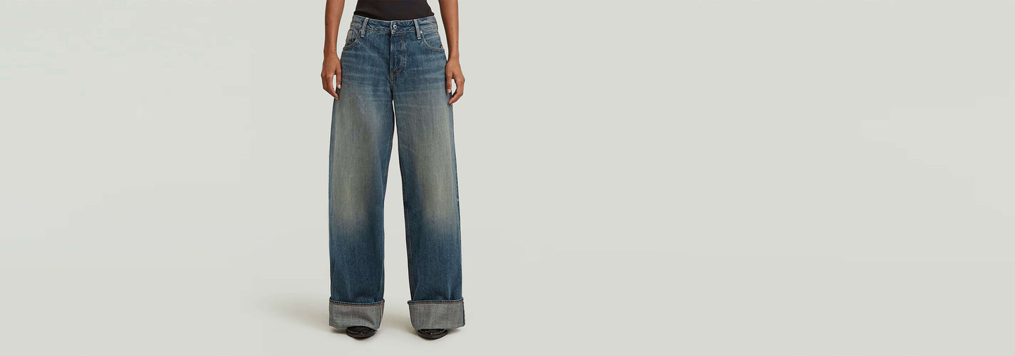Jeans Roxx Wide, corte holgado con tiro medio y dobladillo vuelto, en tintes índigos suaves.