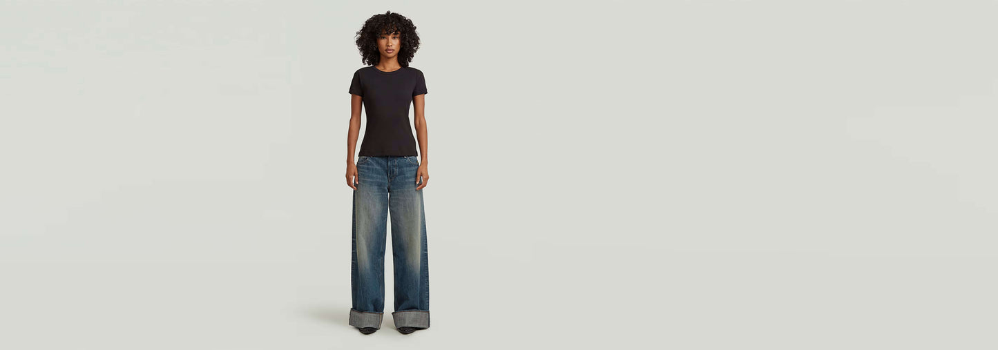 Mujer usando Jeans Roxx Wide con corte holgado y dobladillo vuelto, destacando un estilo contemporáneo.