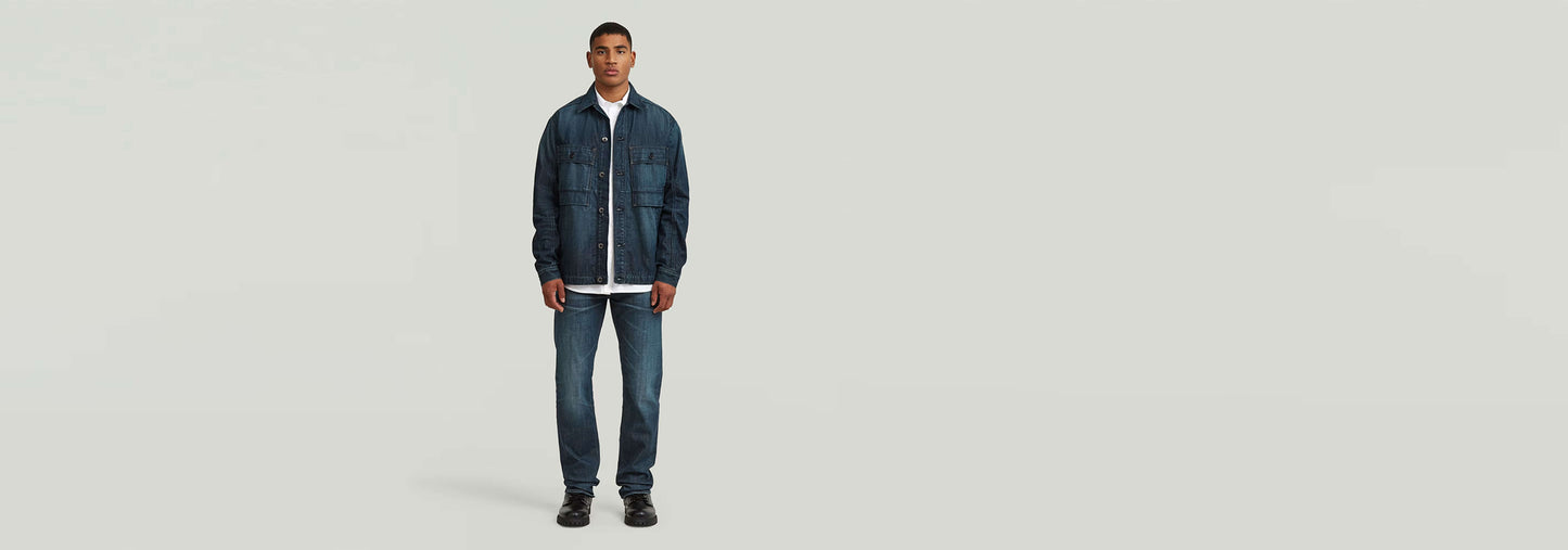 Modelo vistiendo jeans Streem Slim Tapered con chaqueta en un fondo neutro.