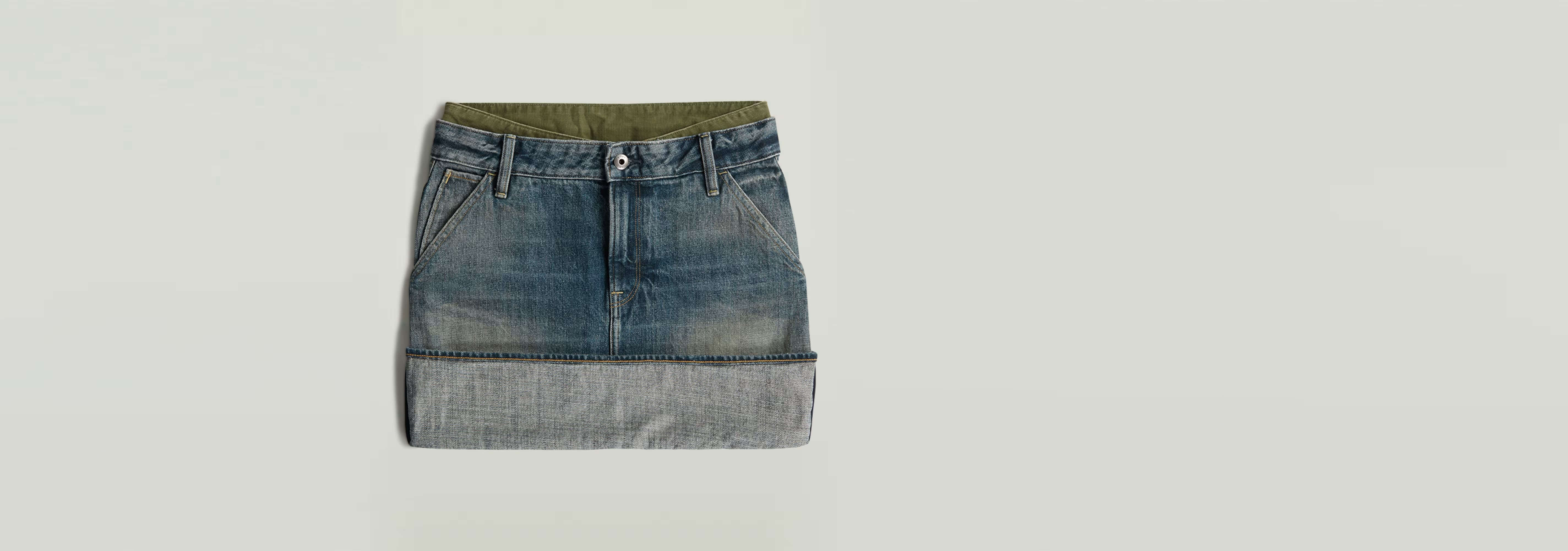 Minifalda con bajo vuelto y paneles en denim greencast con diseño de bloques de color y cierre de cremallera.