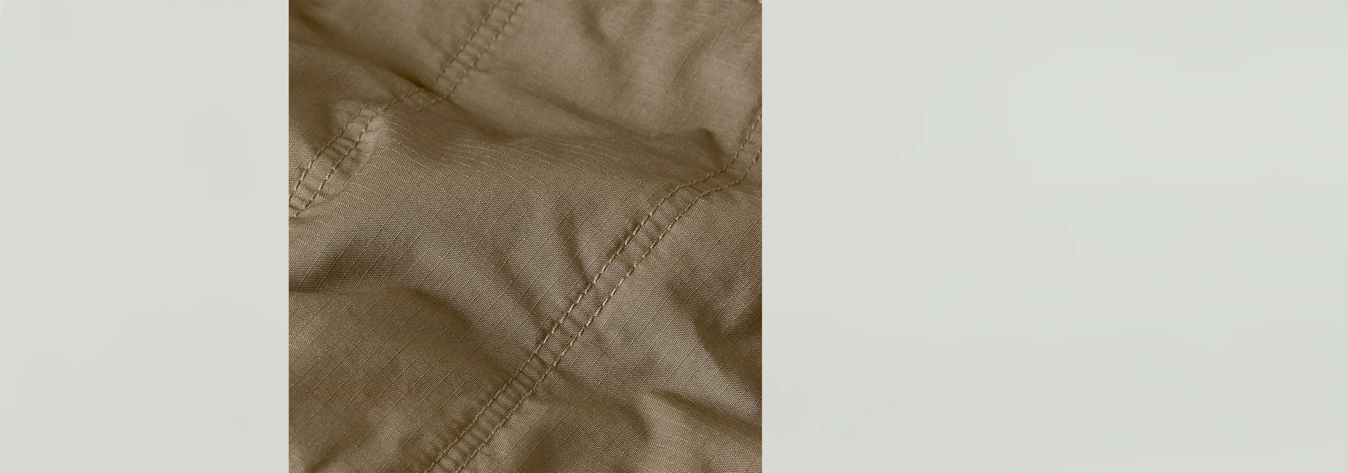 Textura del tejido acolchado de la minifalda Field, con detalles de costura y un color beige elegante.