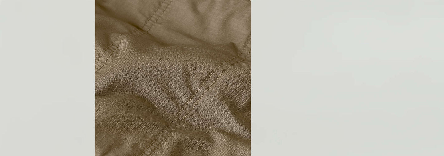 Textura del tejido acolchado de la minifalda Field, con detalles de costura y un color beige elegante.