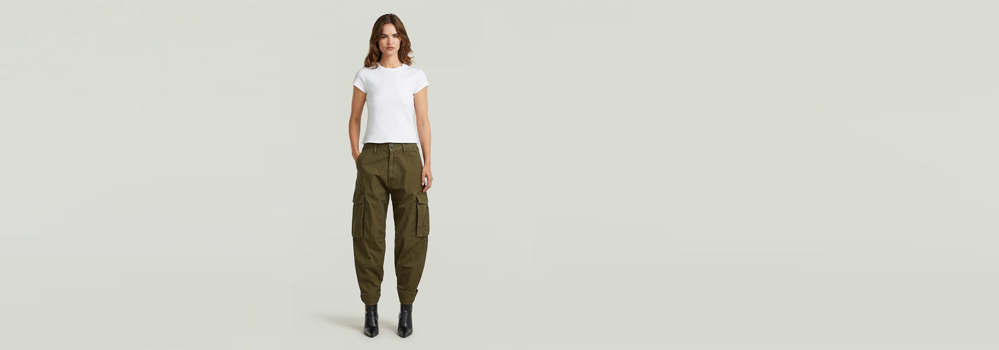 Mujer usando pantalones cargo 3D Boyfriend en color oliva, combinados con camiseta blanca y botas.