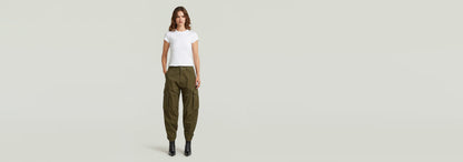 Mujer usando pantalones cargo 3D Boyfriend en color oliva, combinados con camiseta blanca y botas.