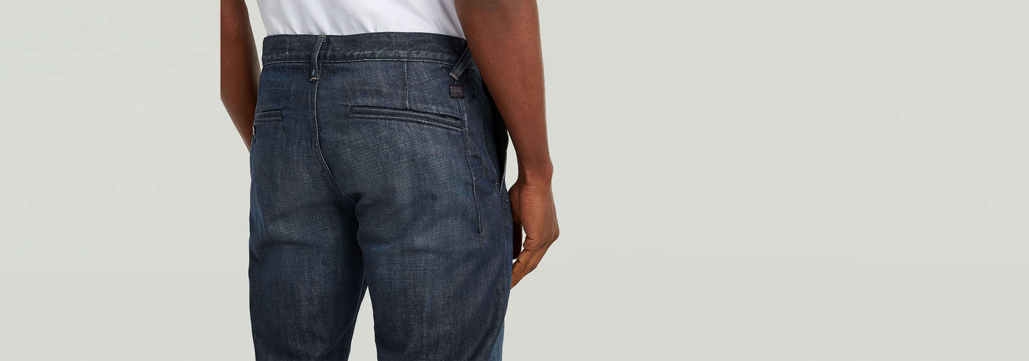 Vista trasera de los pantalones chinos Morry Tapered en denim greencast, mostrando su elegante ajuste cónico.