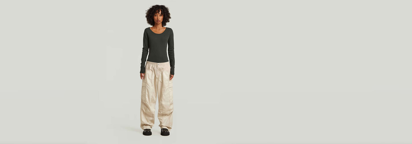 Modelo usando Pantalones Elevated Parachute con corte holgado y cintura alta frente a fondo claro.
