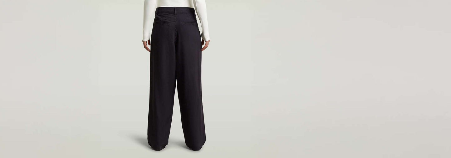 Pantalones Pleated Chino vista trasera, diseño plisado y ajuste recto, fabricados en 90% Viscosa.