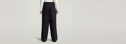 Pantalones Pleated Chino vista trasera, diseño plisado y ajuste recto, fabricados en 90% Viscosa.