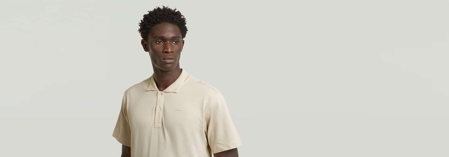 Hombre luciendo la camisa Polo Core Regular en color beige, con cuello de polo y cierre de botones.