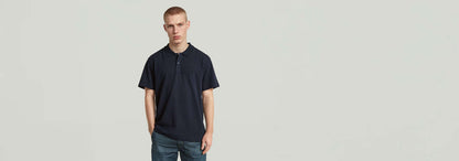 Modelo usando el Polo Core Regular Jacquard en color oscuro, con corte regular y cierre de botones.