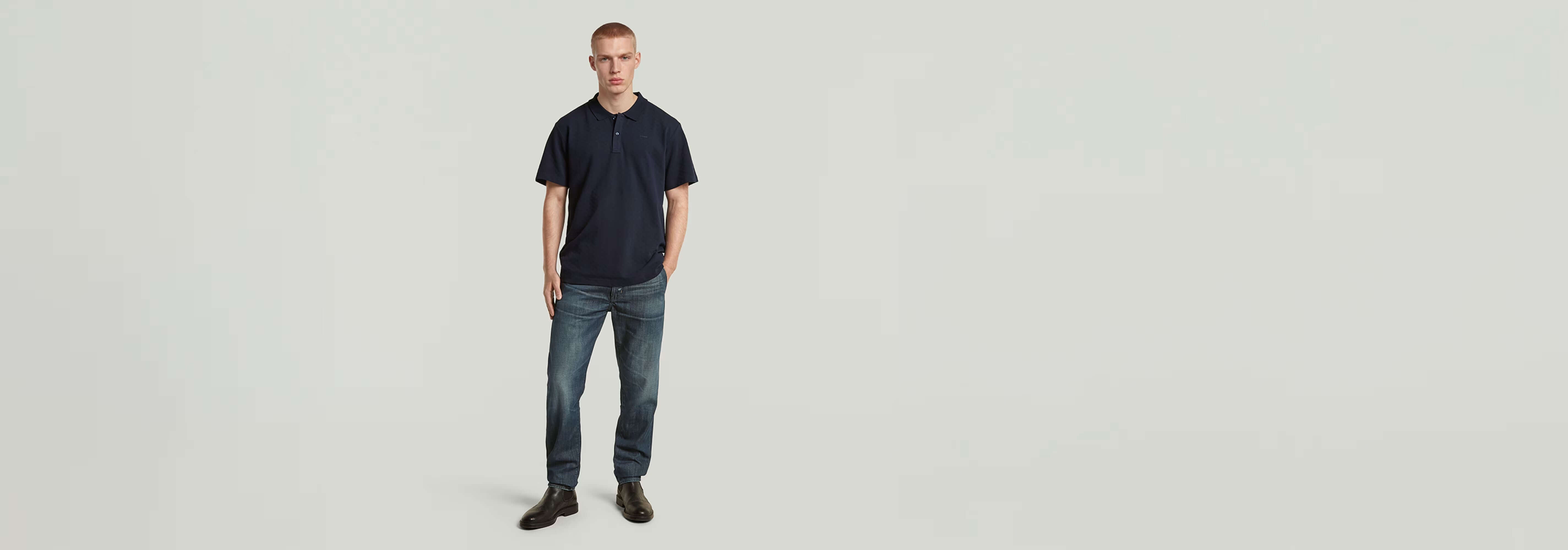 Modelo vistiendo polo Core Regular Jacquard en color azul marino con jeans y zapatos elegantes.