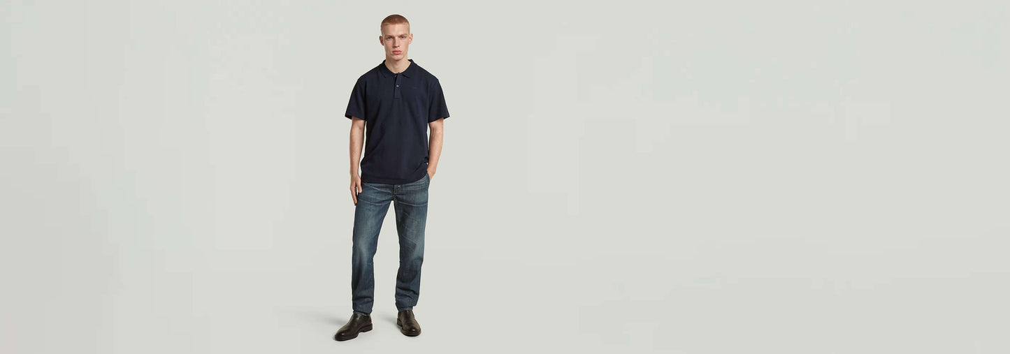 Modelo vistiendo polo Core Regular Jacquard en color azul marino con jeans y zapatos elegantes.