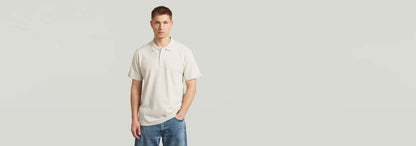 Modelo vistiendo el Polo Core Regular Jacquard en color claro, con diseño clásico y manga corta.