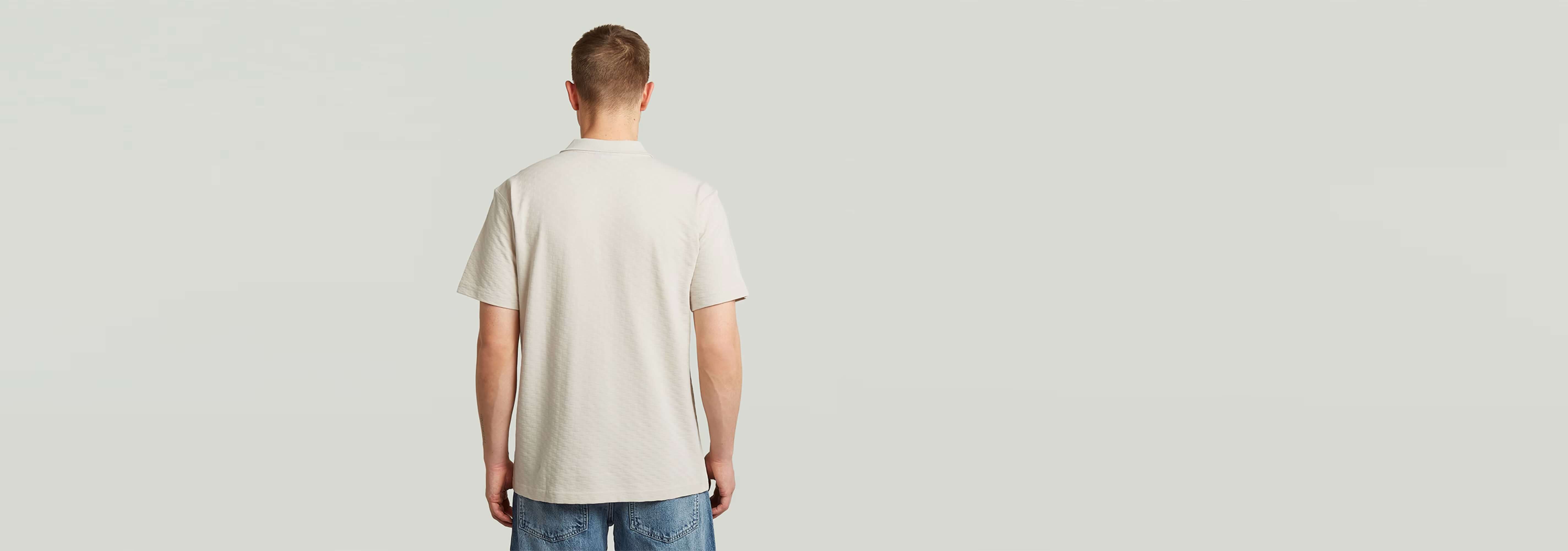 Polo Core Regular Jacquard visto desde atrás, con diseño clásico y cómodo fabricado en algodón ecológico.