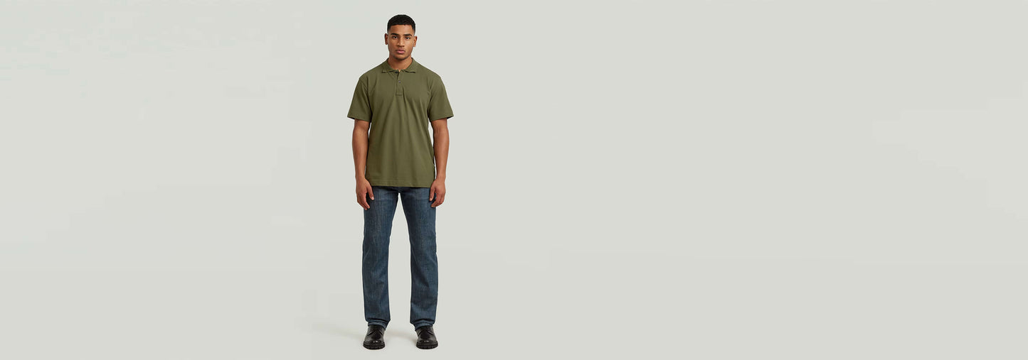 Modelo masculino que lleva el Polo Core Regular en color verde oliva y jeans, fondo neutro.