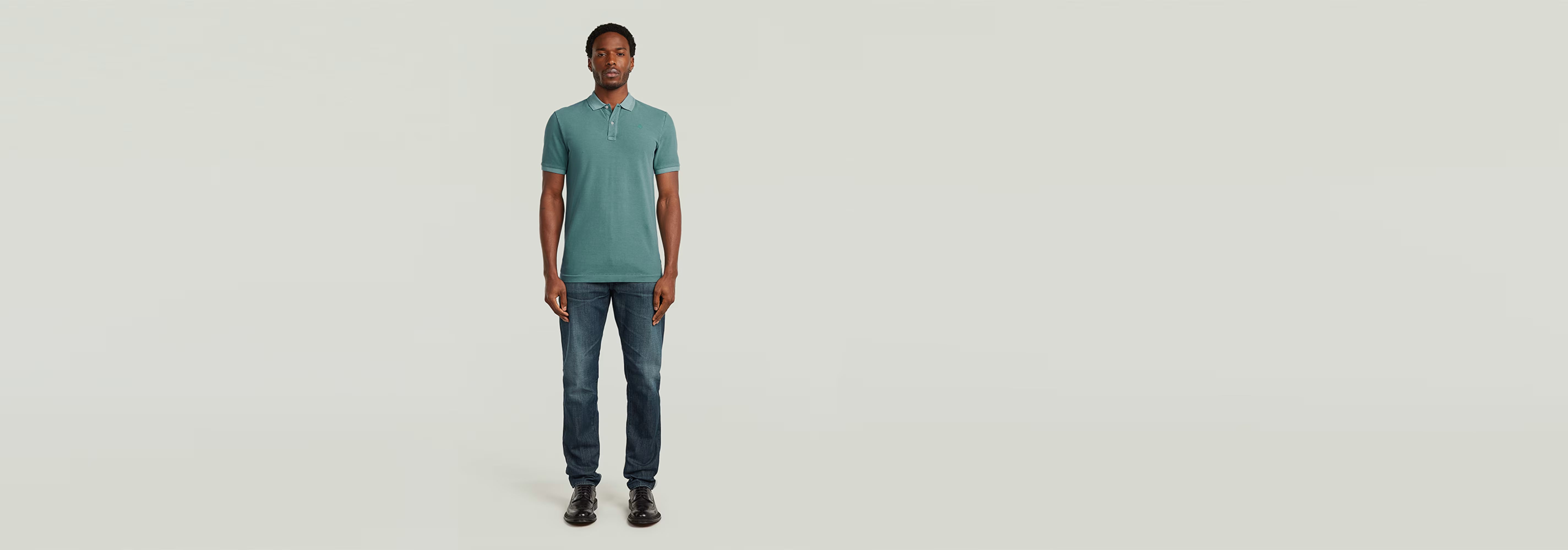 Modelo vistiendo Polo Dunda Overdyed Slim en color verde con jeans en un fondo neutro.